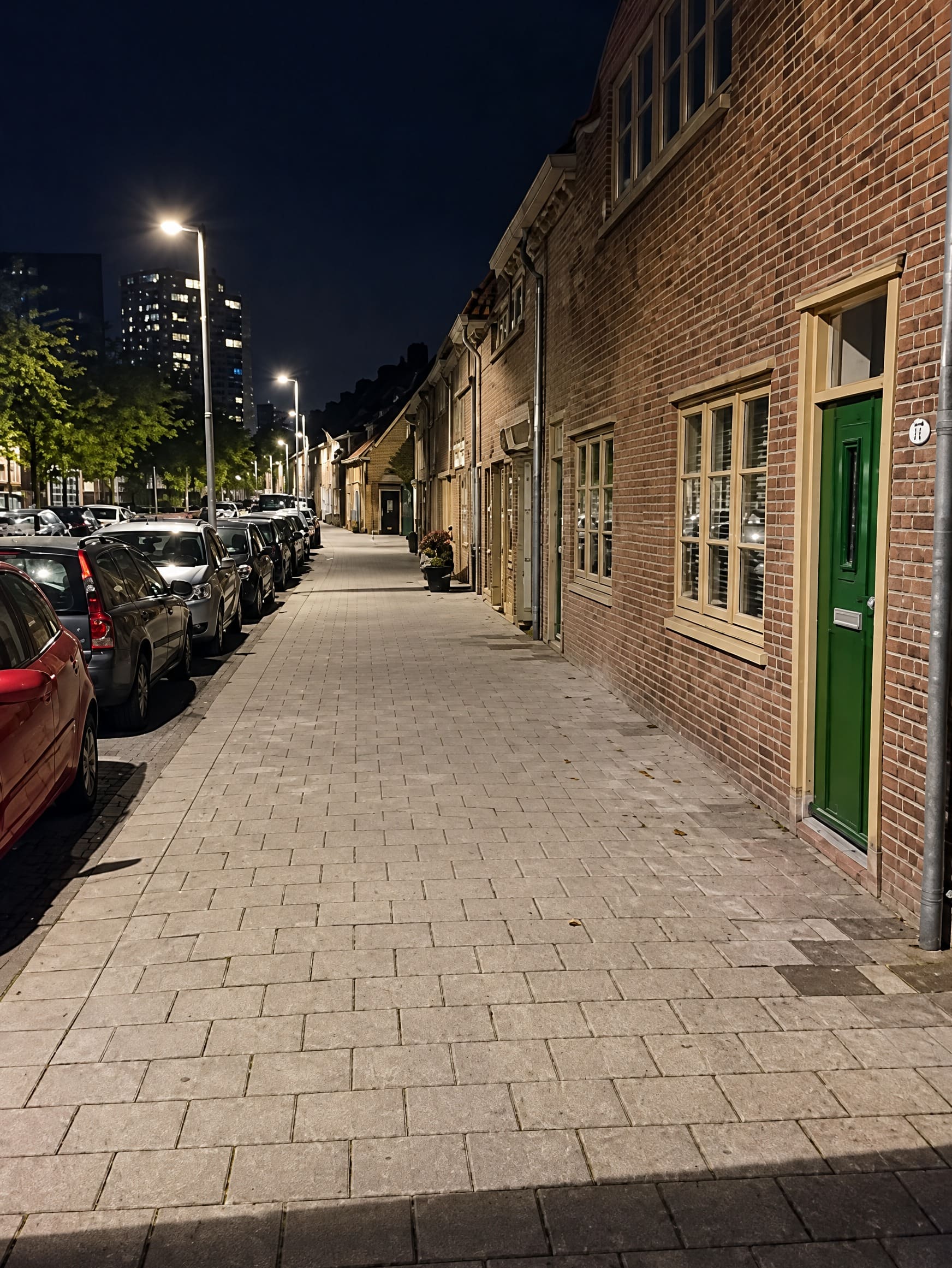 Een rustige zijstraat in Rotterdam-Zuid bij avond, met geparkeerde auto's
